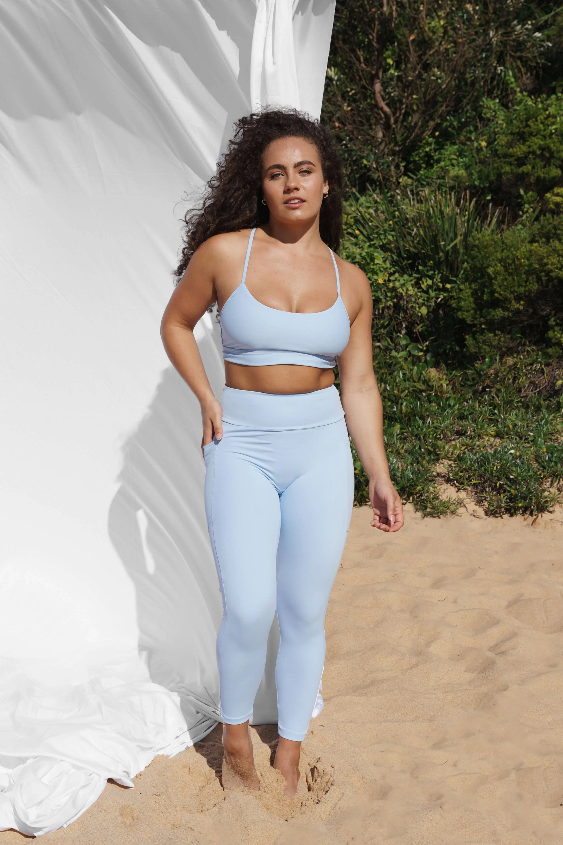Our model at the beach, facing the front wearing a crystal Allawah legging and Inala crop top